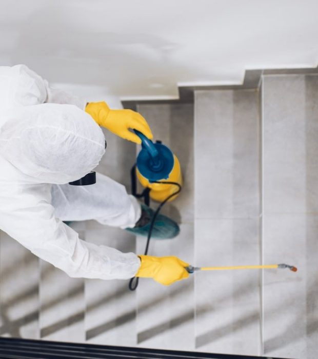 Technician wearing protective gear delivering pest solutions for government buildings in Melbourne